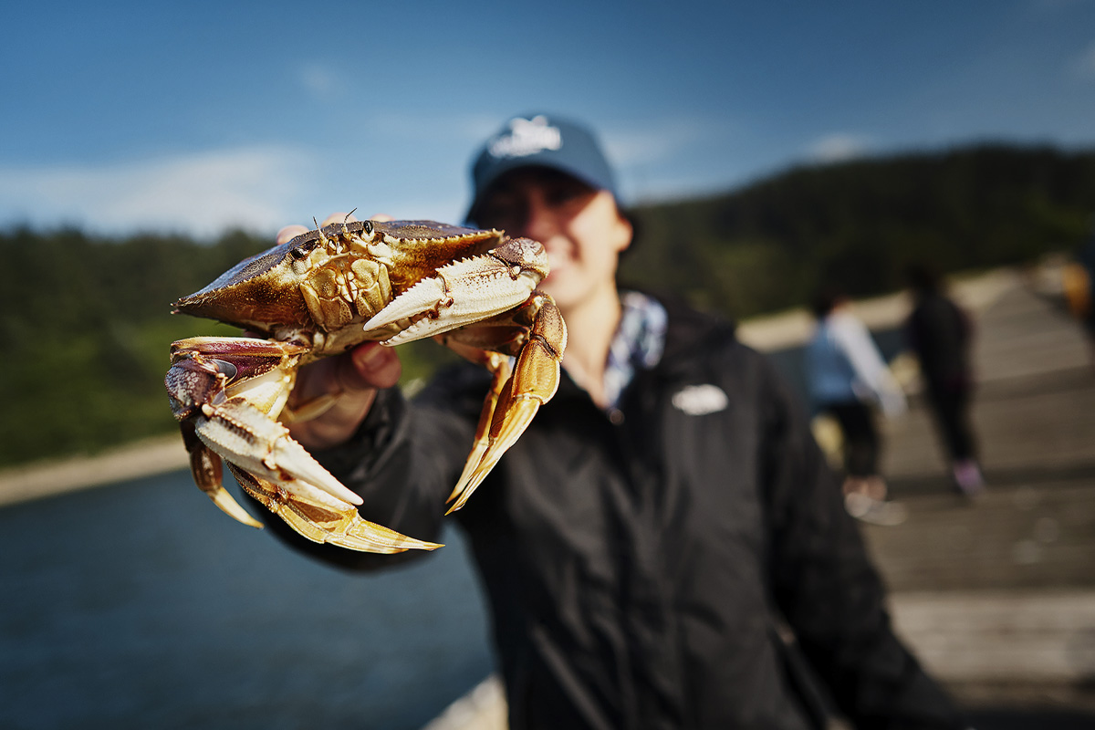 Woman holding crab up close. Photo by Justin Myers.