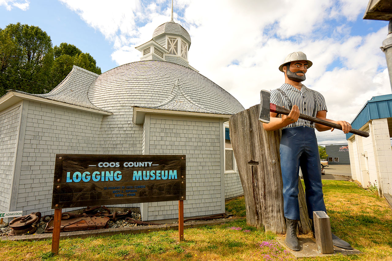 The front of the Coos County Logging Museum with a statue of a logger with an axe, in Myrtle Point, Oregon